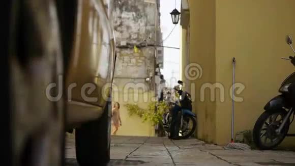 母亲带着孩子走在希腊古城的街道上视频的预览图