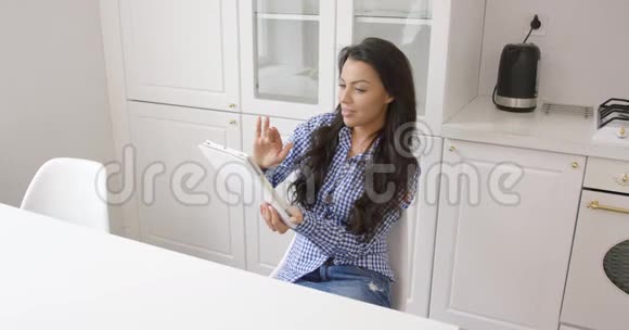 厨房里拿着平板电脑的微笑女人视频的预览图