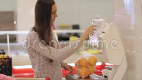 年轻的母亲在超市里她的蔬菜和水果重量很小视频的预览图