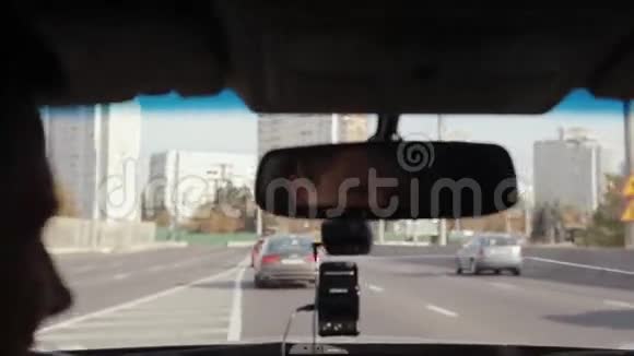 在城市开车的时候对着镜子微笑的人英俊的男人的脸开车旅行视频的预览图