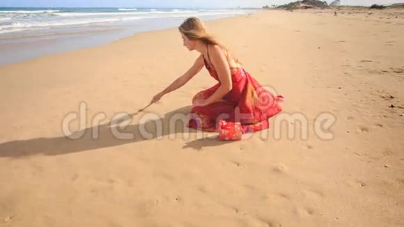 红小队的女人在沙滩上画爱情视频的预览图