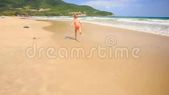 小男孩在海滩边冲浪跑得很远视频的预览图