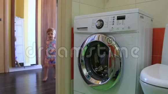 小孩把衣服放进洗衣机视频的预览图