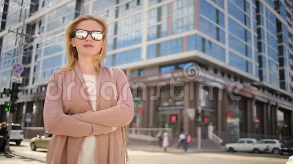 戴墨镜的女人站在繁忙的街道上女人城市的居民视频的预览图