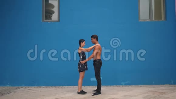 舞蹈伙伴展示感官舞蹈模式与杂技在蓝色背景下缓慢运动户外舞蹈视频的预览图