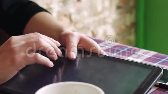 女人用手触摸平板电脑在一张桌子上放着一杯咖啡视频的预览图