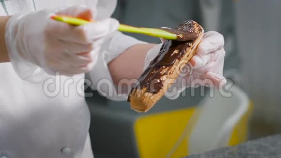 糖果师在刚出炉的蛋糕上轻轻涂抹厚厚的一层巧克力在她最喜欢的工作期间视频的预览图