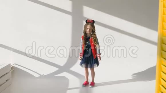 穿着红色夹克有长长辫子的小女孩在摄影棚里唱歌视频的预览图