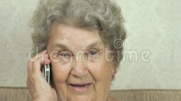 老妇人在家里和医生谈智能手机视频的预览图