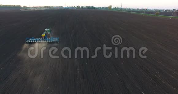 日落时种植小麦的拖拉机的俯视图视频的预览图