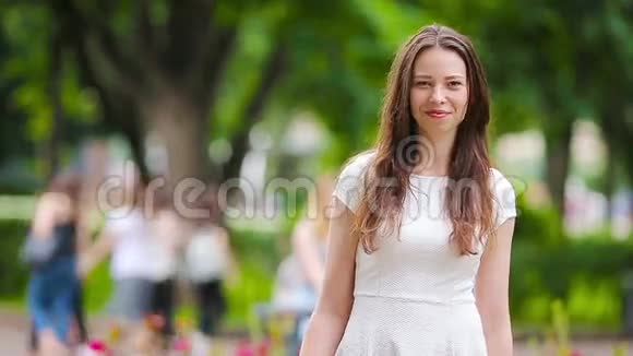 公园里快乐的年轻城市女人的肖像高加索游客在户外享受温暖的夏日视频的预览图
