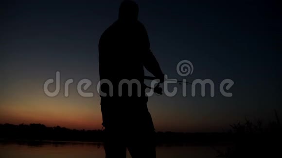 剪影渔夫在背景黄昏的日落中钓鱼视频的预览图