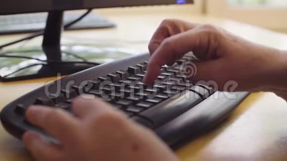 老女人的手在电脑键盘上打字视频的预览图