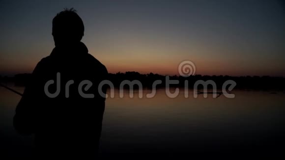 剪影渔夫在夕阳下钓鱼视频的预览图