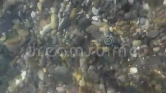 抛光石上方的纯净水面近景视频的预览图