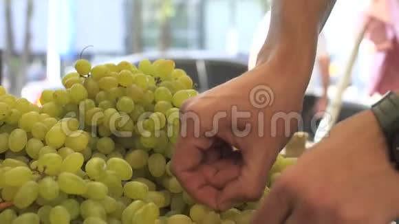 近距离观看年轻人在水果市场挑选葡萄的手视频的预览图