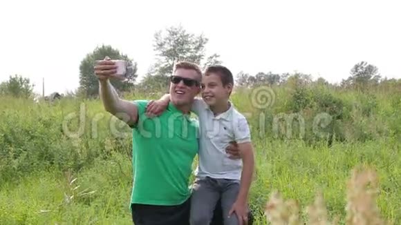 快乐的父子玩耍自己用智能手机拍照视频的预览图