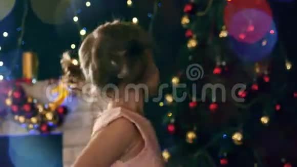 幼儿女孩圣诞树的背景花环的光线模糊视频的预览图