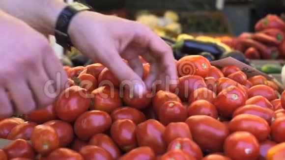 近距离观看年轻人在水果市场选择西红柿的手视频的预览图