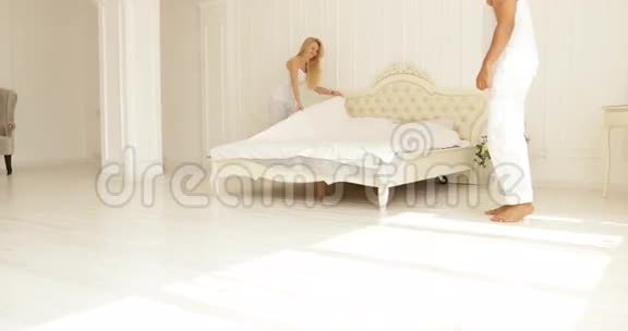 女人把亚麻布放在床上男人拥抱她的两个家庭卧室视频的预览图