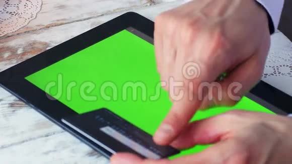 男人正在网上购物手里拿着信用卡和平板电脑空绿的屏幕4k视频的预览图