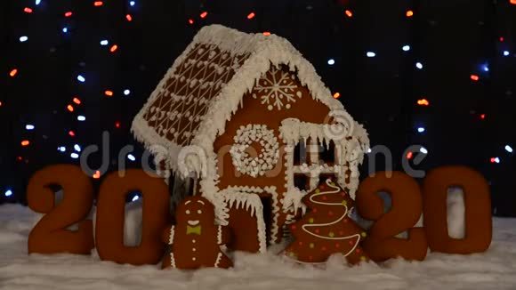 手工制作的可吃姜饼屋2020年铭文小人物新年树雪装饰花环背景视频的预览图