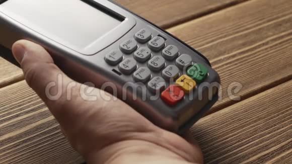 按下按钮的人在pos终端上刷卡付款视频的预览图
