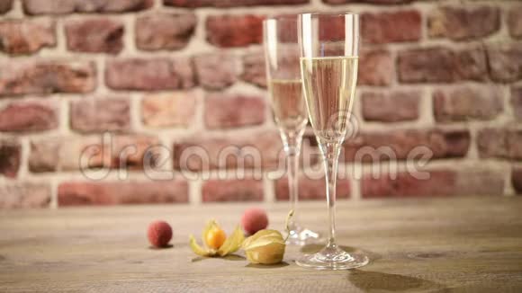 在木桌上将香槟倒入两个凹槽的视频背景是砖有选择性地聚焦视频的预览图