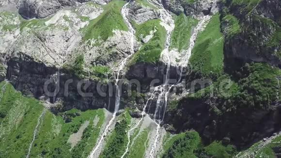 晴天从高山流下来的瀑布从河中流过的山的俯视图视频的预览图