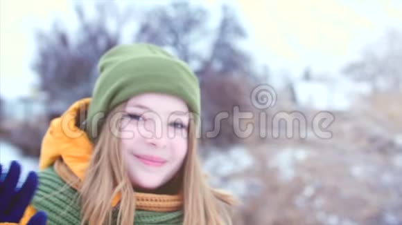一位年轻美丽的少女金发碧眼在户外享受冬日绿棕色女孩的肖像视频的预览图