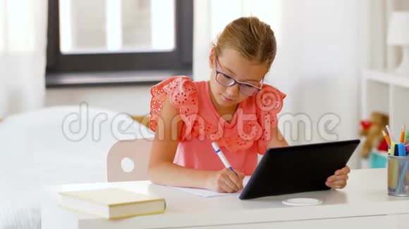 带平板电脑的女孩在家写笔记本视频的预览图
