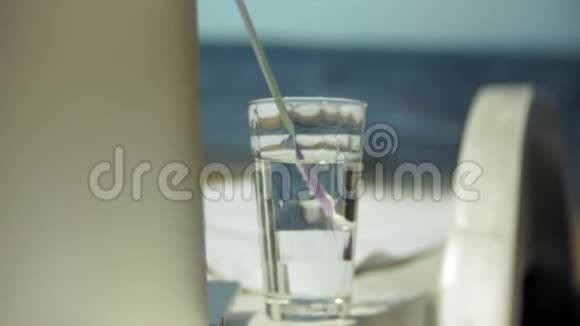 笔记本电脑和一杯水在俯瞰海洋的躺椅上视频的预览图