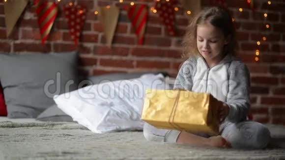 普里特恩的小女孩在节日早晨穿着温暖的圣诞睡衣醒来带着礼物视频的预览图