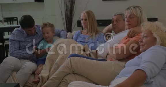 一家人在沙发上一起看电视视频的预览图
