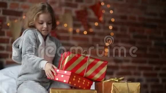 普里特恩的小女孩在节日早晨穿着温暖的圣诞睡衣醒来带着礼物视频的预览图