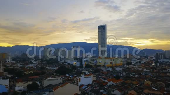 红瓦屋顶历史上的乔治敦城和Komtar塔在槟城岛马来西亚日落鸟瞰图视频的预览图