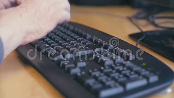 老女人的手在电脑键盘上打字视频的预览图
