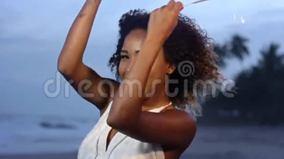 一个美丽的女人在沙滩上慢动作地跳舞和庆祝视频的预览图