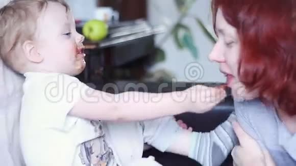 小男孩嘴上抹着巧克力给妈妈吃视频的预览图