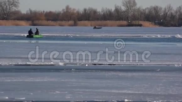在冰上移动的运输冬天两个人在船上在冬天在河上渡渡视频的预览图