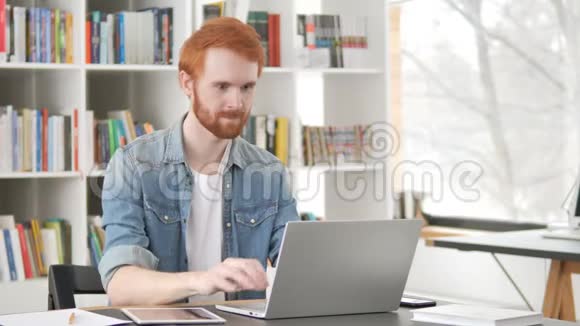 休闲红发男子在笔记本电脑上的在线视频聊天视频的预览图
