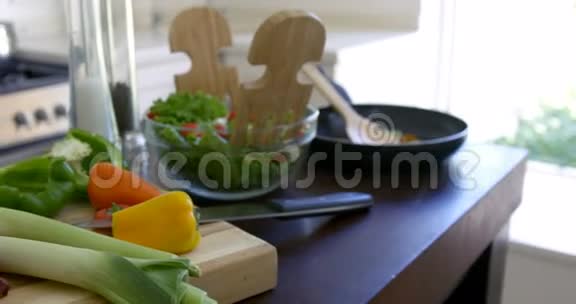碗沙拉和新鲜蔬菜放在厨房的工作台上视频的预览图