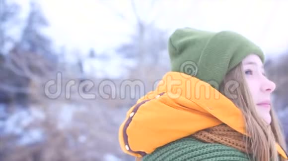 一个年轻美丽的少女金发在户外享受冬日一个绿棕色女孩的肖像视频的预览图