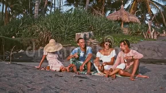 年轻人在海滩上玩得很开心岛上的周末朋友们一起在海边玩唱歌和野餐视频的预览图
