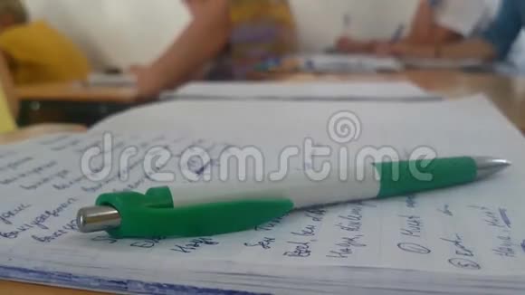 笔记本上的钢笔教室里手写的文字特写镜头视频的预览图