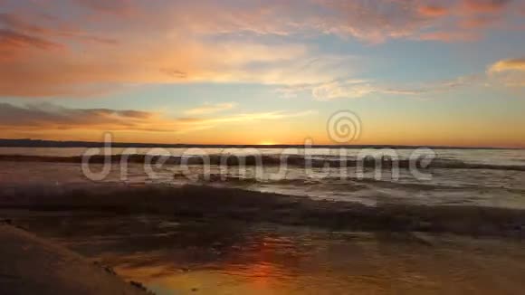 波浪在沙岸上翻滚傍晚时分太阳已经超越了地平线在远处另一个大湖岸视频的预览图