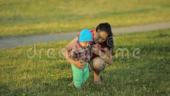 妈妈在公园里和小儿子玩孩子迈出第一步视频的预览图