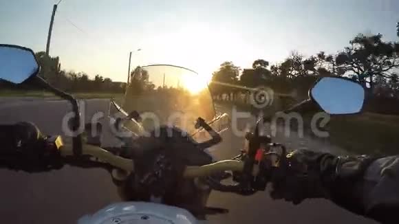 日落时骑摩托车者在城镇道路上高速行驶的视角摩托车驾驶的观点视频的预览图