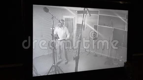 人在录音室对着麦克风唱歌监控摄像头交叉武器视频的预览图