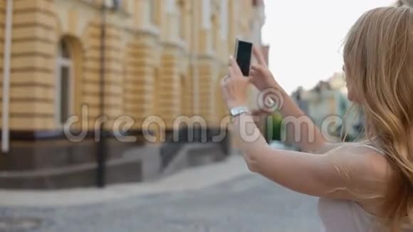 女人用手机拍摄建筑物视频的预览图